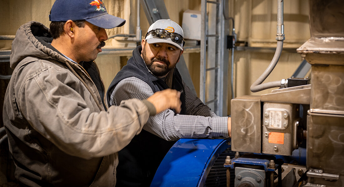 Two men talking about the large machine in front of them